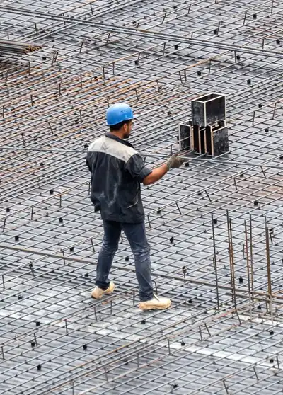 Muncitor pe armătura unui planșeu, înainte de turnarea betonului